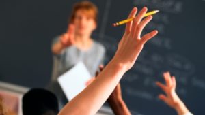 Person raising hand in classroom