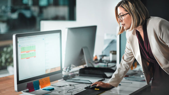 Business woman looking at large computer monitor